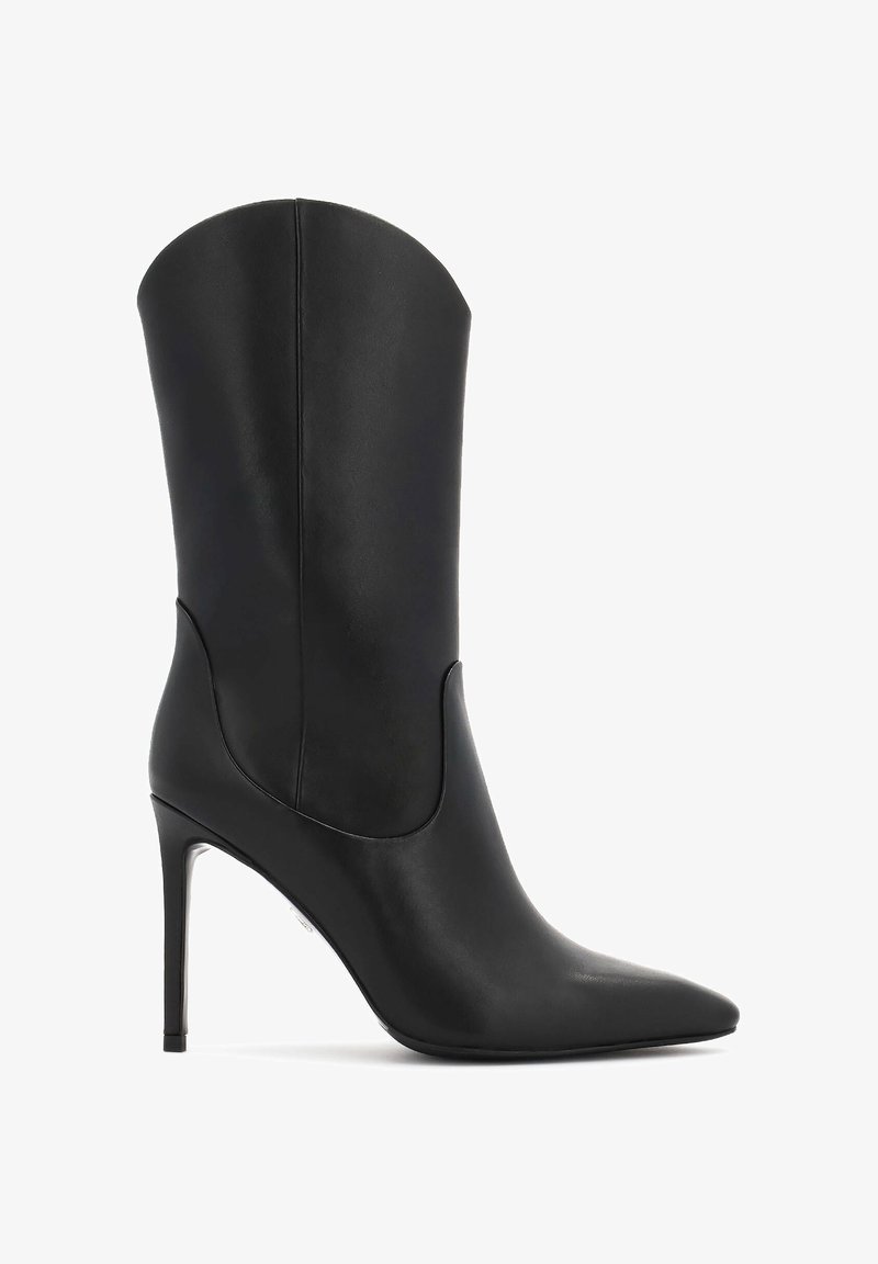 Bota alta de cuero negro con tacón y punta afilada. Presenta un diseño curvado, textura suave y un acento metálico en el tacón.