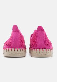 Scarpe slip-on in suede rosa con fori decorativi e suole in gomma beige. Presentano dettagli di cucitura e branding sul tallone.