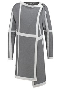 Long gilet en maille grise avec motif géométrique blanc en grille, ourlet asymétrique, manches longues, encolure bateau et détail de boucle sur le côté.