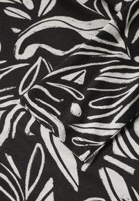 Schwarzer Stoff mit einem mutigen abstrakten Muster in Weiß, das sich mit wirbelnden Linien und Blattformen präsentiert. Weiche Textur, geeignet für verschiedene Textilanwendungen.