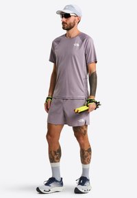 Light purple athletic shirt and shorts, made of moisture-wicking fabric. Accessories include a light blue cap and dark sunglasses.
