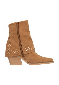 Botas de tobillo de ante en tono beige con cierre de cremallera, puntera afinada y tacón de madera. Presentan tachuelas metálicas decorativas en el lado exterior.