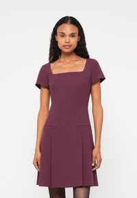 Rochie bordeaux cu mâneci scurte, decolteu pătrat și două buzunare în față. Fustă evazată și textură netedă. Design minimalist.