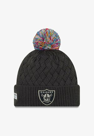 Bonnet en tricot noir avec un pompon coloré sur le dessus, comportant un patch de logo des Raiders à l'avant et un poignet côtelé à la base.