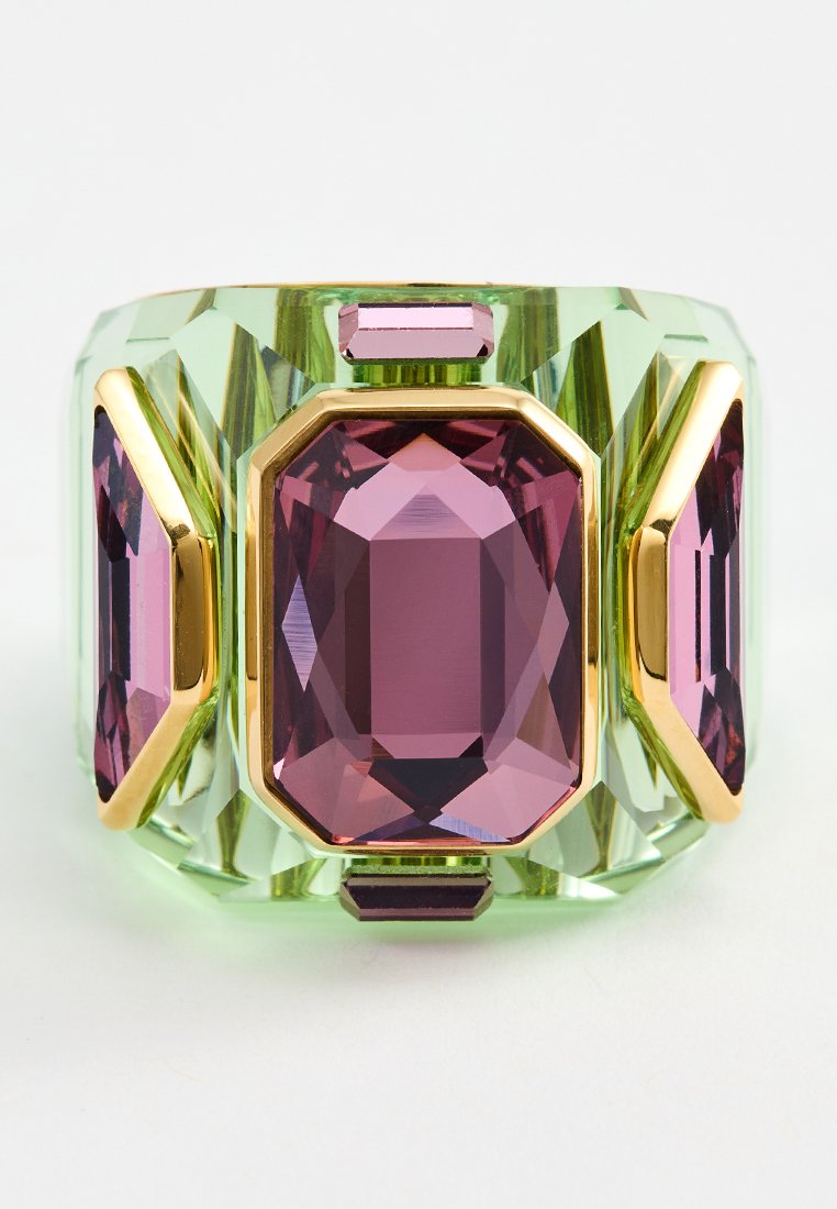 Bague en acrylique verte avec trois grandes pierres octogonales violettes et des accents dorés. Le design facetté ajoute de la texture et de la profondeur.