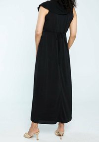 Robe maxi noire avec un col drapé, taille cintrée à cordon et manches courtes. Tissu lisse avec une silhouette fluide.
