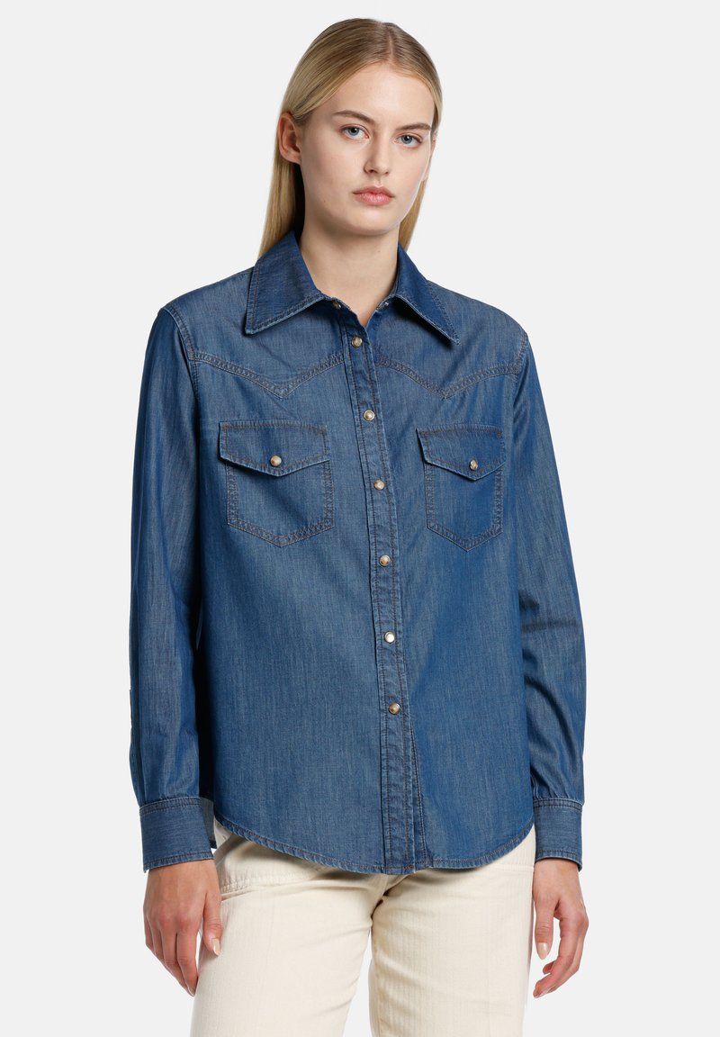 Denim srajca s pritisnimi gumbi v temno modri barvi, z ostrim ovratnikom, sprednjimi žepi na prsih in svetlim šivanjem. Dolgi rokavi s pritisnimi manšetami.
