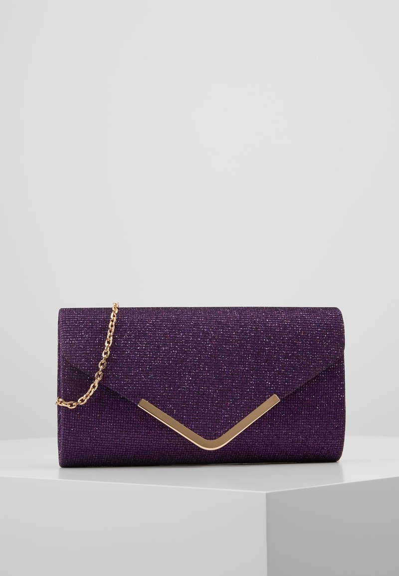 Pochette rectangulaire glitter violette avec accent doré en forme de V et bandoulière chaîne dorée sur un socle blanc sur fond gris clair.