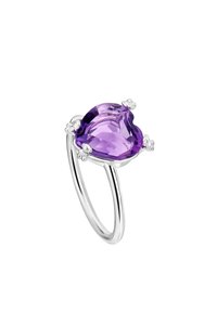 Anillo de plata con una gran gema púrpura en forma de corazón, sostenida por acentos florales en el engaste, con una banda lisa y pulida.
