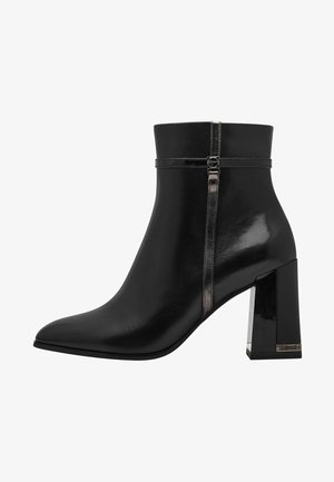 Bottines en cuir noir avec un bout pointu, finition brillante, talon bloc et fermeture éclair sur le côté, ornées d'accents métalliques et d'une sangle étroite.