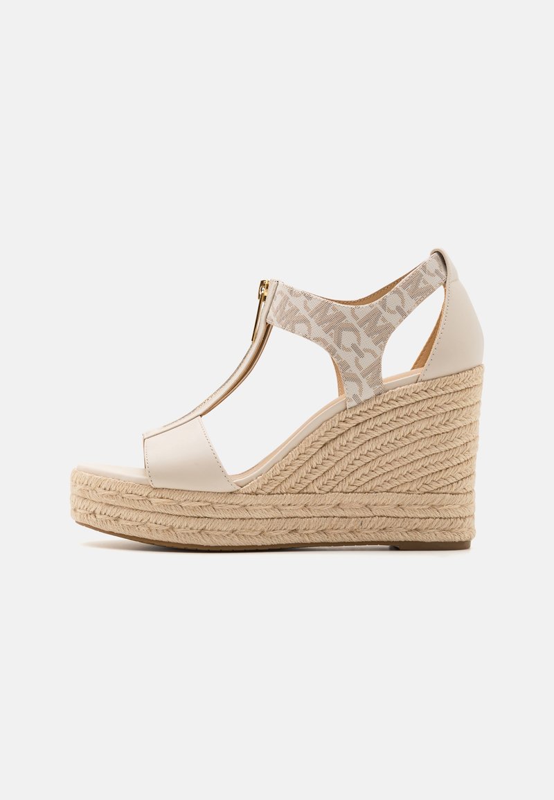 Sandale compensée beige avec plateforme en jute tressée, design à bride en T et fermeture éclair sur la bride de cheville avec détail en tissu à motifs.