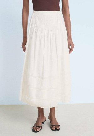 White, ankle-length skirt made from lightweight fabric with a textured waistband, featuring subtle horizontal stitching and gathered design.