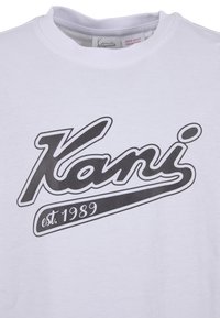 Λευκό t-shirt με στρογγυλή λαιμόκοψη και μαύρο λογότυπο "Kani est. 1989" τυπωμένο στο κέντρο μπροστά, κάτω από το γιακά.