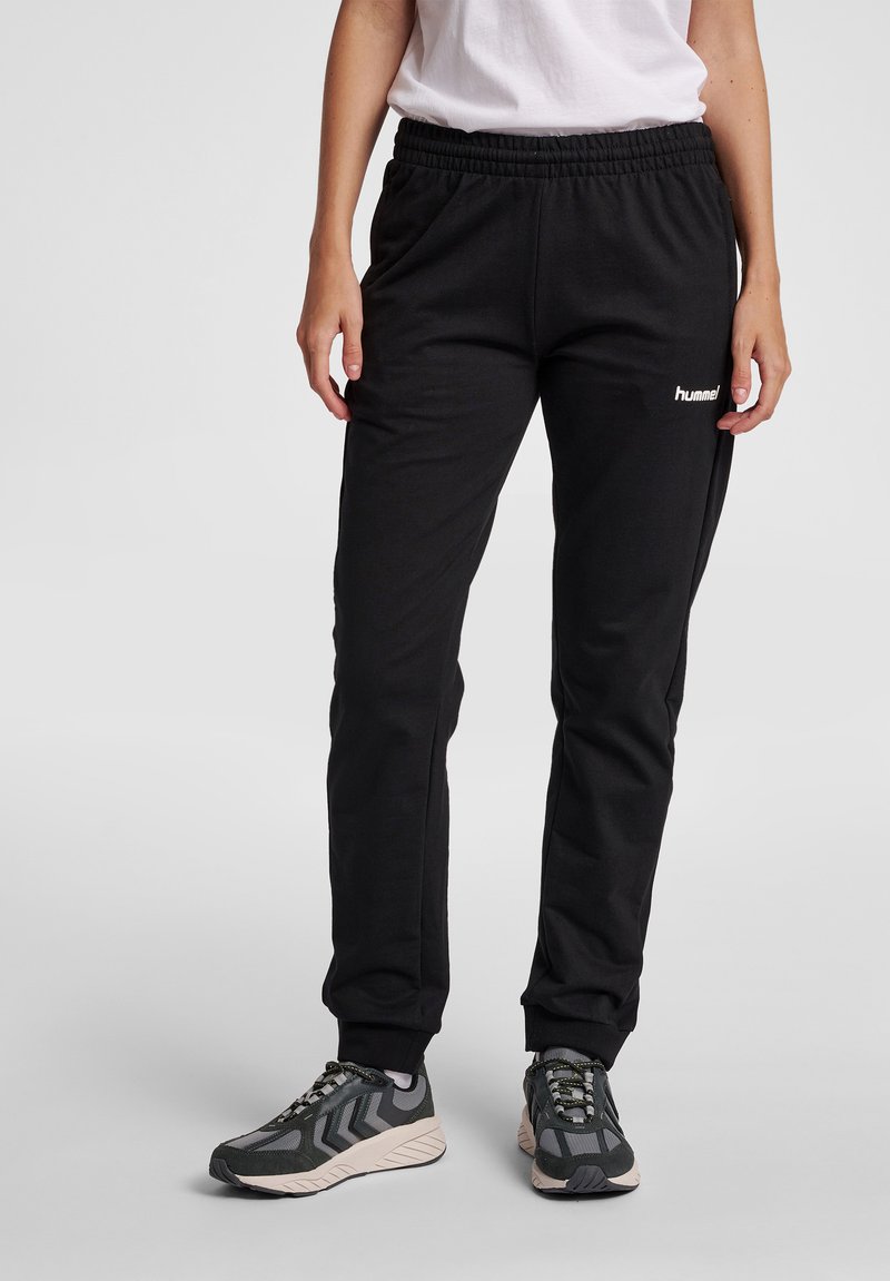 Svarta joggingbyxor i mjukt tyg med resår i midjan. Har sidofickor och en liten vit logotyp på vänster ben.