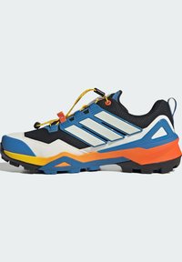 Αθλητικό παπούτσι με μαύρο, μπλε και άσπρο επάνω μέρος, με πορτοκαλί και κίτρινες λεπτομέρειες. Υφή σόλας με έντονα πέλματα. Ανακλαστικές ρίγες.