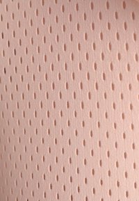 Jasnoróżowa siatkowa tkanina z małymi owalnymi perforacjami, tworząca teksturowaną powierzchnię. Materiał wydaje się miękki i przewiewny.