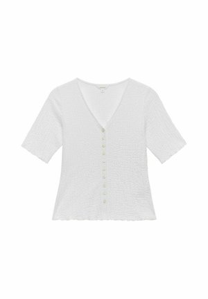 Weiße Bluse mit kurzen Ärmeln, V-Ausschnitt, strukturiertem Stoff und einer Reihe von sechs grünen Knöpfen auf der Vorderseite. Verziert mit einem wellenförmigen Saum.