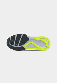 Εξωτερική σόλα παπουτσιού με μαύρα και νέον κίτρινα λαστιχένια πέλματα, γκρι μεσαία σόλα και μικρό ανάγλυφο λογότυπο Swoosh κοντά στην καμάρα.