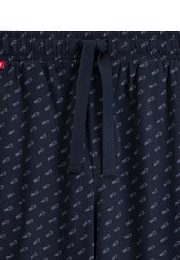 Granatowe szorty z miękkiego materiału, pokryte wzorem z logo, z elastycznym pasem i regulowanym sznurkiem dla wygodnego dopasowania.