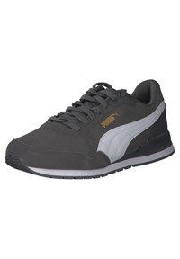Baskets Puma gris foncé avec bande blanche, lacets gris assortis et logo Puma doré sur le côté, montrant le côté extérieur et l'avant.