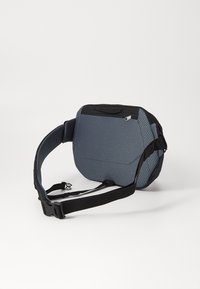 Gray, textured fabric shoulder bag with black accents, adjustable strap, and zippered pocket on top. Compact, ergonomic design.