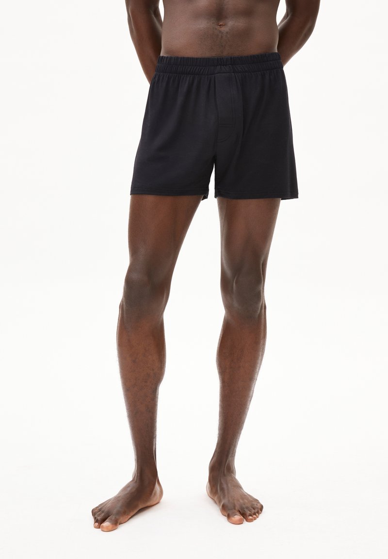 Zwarte katoenen boxers met een elastische tailleband en een relaxte pasvorm, met een gladde textuur en een minimalistisch ontwerp.