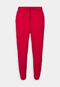 Rote Jogginghosen aus weichem Material, mit einem elastischen Bund und einem Kordelzug, gerippten Bündchen und einem kleinen schwarzen Logo an der Seite.