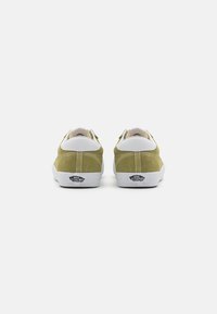Green suede shoes with white leather accents, low-top design, and a rubber sole. Features a logo at the heel and stitched detailing.