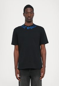 Svart bomullströja med blå broderad text runt halsringningen, design med rund hals och korta ärmar. Texten säger "Just Cavalli."