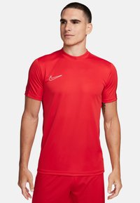 Rotes Sportshirt aus glattem, leichtem Material. Mit Rundhalsausschnitt, kurzen Ärmeln und einem weißen Nike-Logo auf der linken Brust.