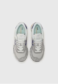 Gray mesh and suede sneakers with white laces, blue accents, and a tan sole. Features a padded collar and prominent branding on tongue.