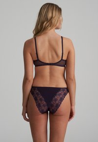 Marine kanten lingerie set met een doorzichtige beha en broekje, versierd met bloemenborduursel en golfachtige randen, die de fijne afwerking benadrukken.