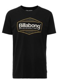 Svart bomull t-shirt med en stor guld- och vit Billabong-logotyp samt texten "SINCE NINETEEN SEVENTY THREE", rund halsringning och korta ärmar.