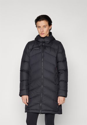 Black insulated puffer coat with a chevron pattern, zip closure, hood, and side pockets. Material appears smooth and lightweight.