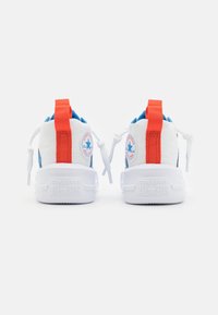 Weiße Sneakers mit blauen Akzenten, rotem Ferseneinsatz und weißen Gummisohlen. Enthält Converse-Logo-Patches und strukturierte Stoffdetails.