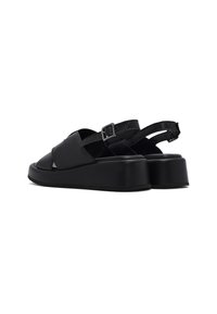 Sandali platform neri realizzati in pelle liscia, con punta aperta, cinghie incrociate e fibbia regolabile alla caviglia per una vestibilità sicura.