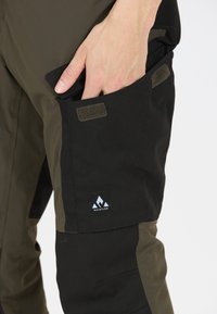 Zwarte en olijfgroene cargobroek met een zijzak, klittenbandsluiting en een logo-label. De stof lijkt duurzaam en weersbestendig.