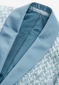 Blazer azzurro cielo con una finitura satinata liscia, caratterizzato da un tessuto stampato con forme geometriche, un collo a scollo e una fodera interna.
