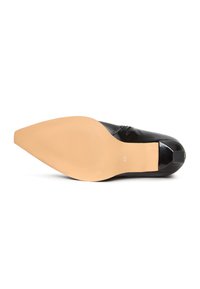 Zwarte gepatineerde leren schoen met een slanke, spitse neus en een tan rubberen zool. Heeft een gestructureerde afwerking en een kleine accent bij de hak.