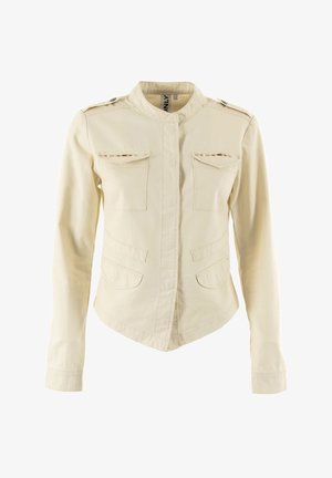 Giacca in tela beige chiaro con colletto stand, due tasche sul petto e cuciture decorative. Maniche lunghe e taglio aderente.