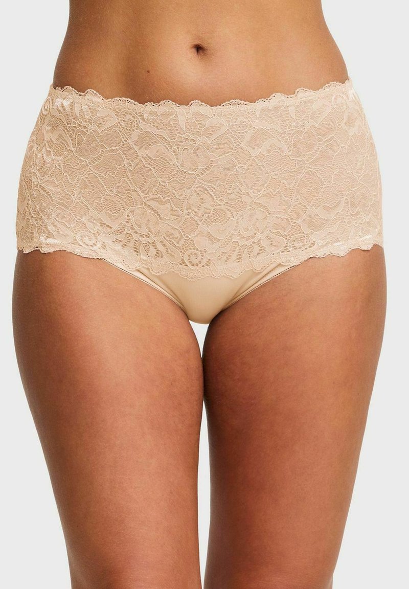 Beige högmidjade spetsunderbyxor med blommönster, bärs av en person med medium hudton, visad från midjan till mitten av låret.
