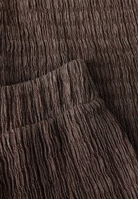 Tissu brun foncé texturé avec des côtes verticales, doté d'une taille élastiquée et d'une surface douce légèrement brillante.