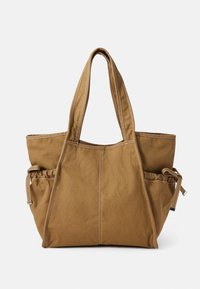 Borsa tote in tela marrone con doppie maniglie e tasche laterali arricciate con chiusure a coulisse, esposta su uno sfondo bianco.