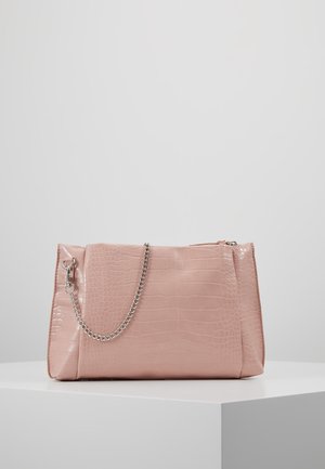 Lichtroze croco-geïmpregneerde leren handtas met een zilveren kettingriem, rustend op een wit voetstuk tegen een effen achtergrond.