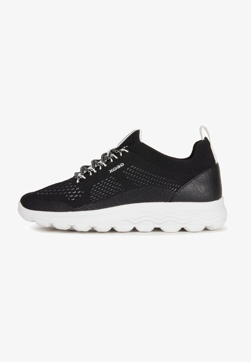 Black knitted athletic shoe with a white rubber sole, featuring a mesh design, reflective laces, and a textured heel accent.