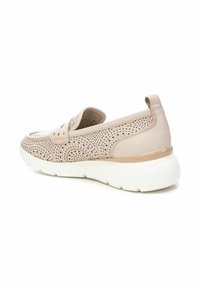 Zapato slip-on de cuero perforado en color beige con un talón elevado, suela gruesa blanca y sutiles acentos dorados cerca del talón.