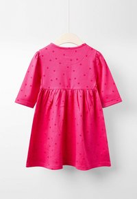 Rosa Pünktchenkleid mit langen Ärmeln, rundem Ausschnitt und gerafftem Rock. Hergestellt aus weichem Stoff, der eine glatte Textur und lebendige Farbe bietet.
