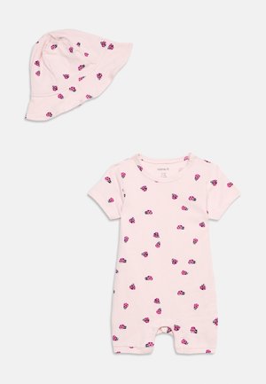 Light pink baby romper and matching sun hat with scattered pink and black ladybug prints.