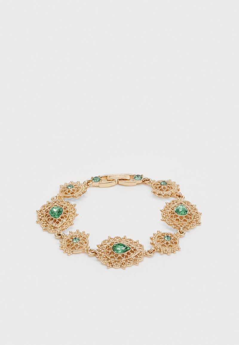 Pulsera en tono dorado con un intrincado diseño similar al encaje, adornada con múltiples gemas verdes de diferentes formas, incluyendo redondas y en forma de lágrima.