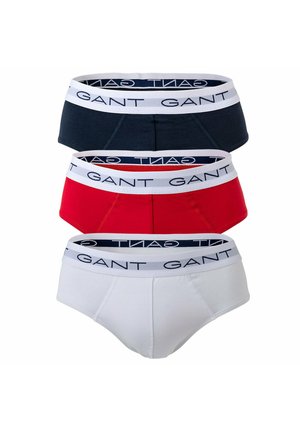 Drei Herren-Slips in Marineblau, Rot und Weiß. Jeder hat einen kontrastierenden Bund mit "GANT"-Logo. Material aus Baumwollmischung.